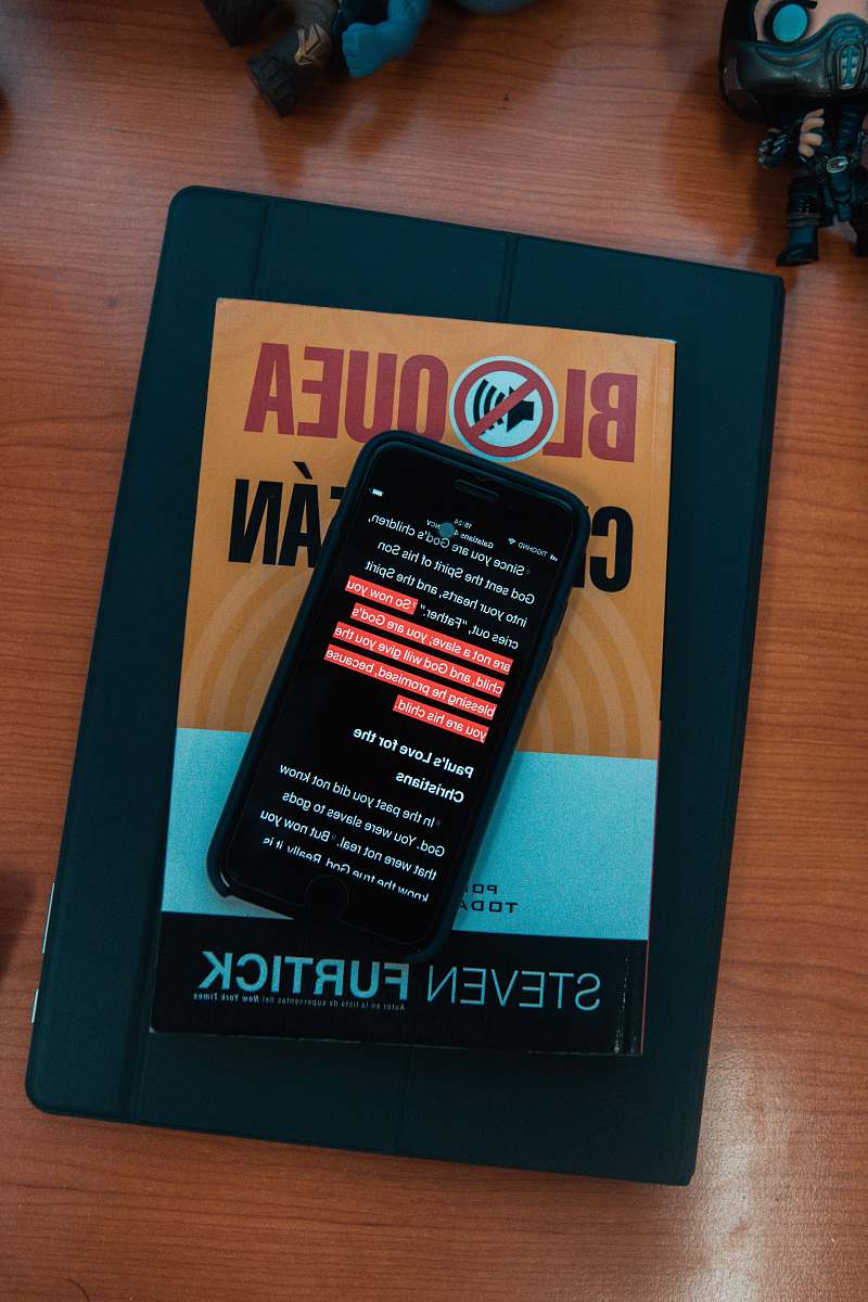 cell phone black smartphone on top of Steven Furtick book electronics
